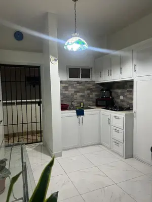 a kitchen with white cabinets and a blue light at Bello y acogedor Apartamento in Santiago de los Caballeros