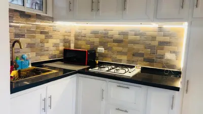 a kitchen with a counter top with a stove and a microwave at Bello y acogedor Apartamento in Santiago de los Caballeros