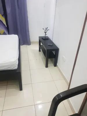 a room with a table and a bed and a chair at Fantástico y pequeño estudio in Santiago de los Caballeros
