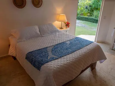 a bed with a blue and white comforter in a bedroom at JandalaVillage in Las Terrenas