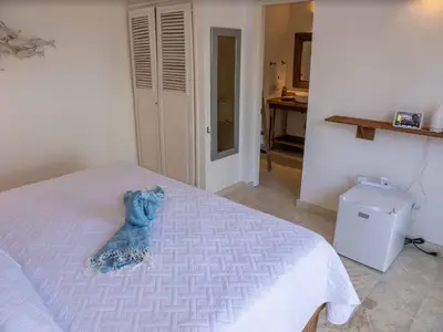 a stuffed animal is sitting on a bed at JandalaVillage in Las Terrenas