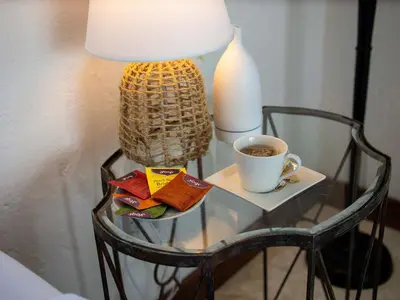 a glass table with a lamp and a cup of coffee at JandalaVillage in Las Terrenas