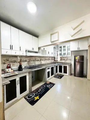 a large kitchen with white cabinets and a counter top at Cerca del divino niño I WiFi I TV in Constanza