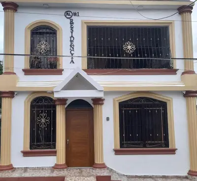 a white house with two windows and a door at Cerca del divino niño I WiFi I TV in Constanza
