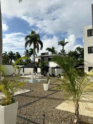 a courtyard with palm trees and a building at Level suites Penthouse in Sosúa
