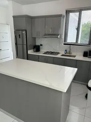 a white kitchen with a white counter top at Level suites Penthouse in Sosúa