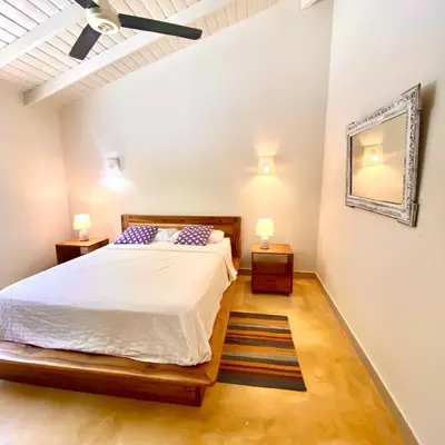 a bedroom with a bed and two night stands at Casa Del Sol in El Limón