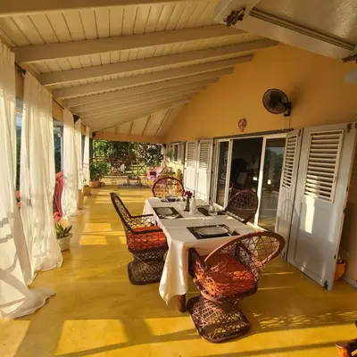 a patio with a table and chairs on a porch at Casa Del Sol in El Limón