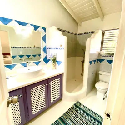 a bathroom with a sink and a toilet and a mirror at Casa Del Sol in El Limón