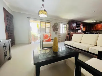 a living room with a couch and a table at Cozy 2 bed apartment garden views close to Playa Bavaro in Punta Cana