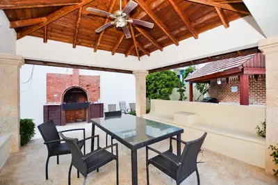an outdoor patio with a glass table and chairs at Cozy 2 bed apartment garden views close to Playa Bavaro in Punta Cana