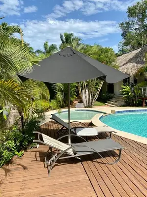 a table and chairs with an umbrella next to a pool at Chalet tropical au cœur de Las Terrenas in Las Terrenas