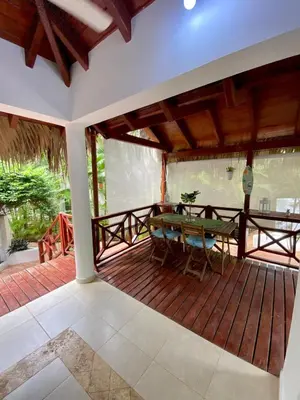 a wooden deck with a table and chairs on it at Chalet tropical au cœur de Las Terrenas in Las Terrenas