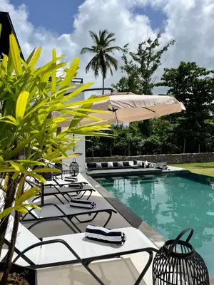 a pool with chairs and umbrellas next to a resort at Casa black and white frente al mar in Las Galeras