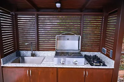 an outdoor kitchen with a stove and a sink at The Domes Jarabacoa in Jarabacoa