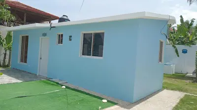 a house with a blue garage with golf balls in the yard at Villa el real los patos in Los Patos