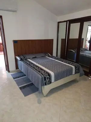 a bed in a bedroom with a wooden headboard at Acuario residencial 1 in La Viva