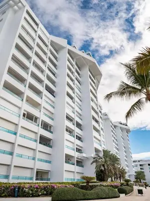 a large white building with palm trees in front of it at SuiteDelux Oceanview Marbella 3BDR in Juan Pedro