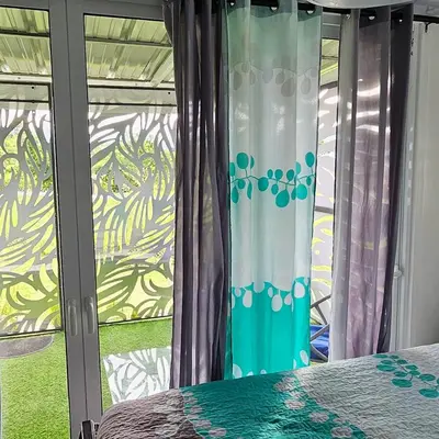 a bedroom with a window with curtains and a bed at BlueEcolandia bungalows AIRE in Jarabacoa