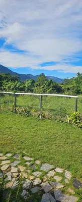a fence in the middle of a grass field at BlueEcolandia bungalows AIRE in Jarabacoa
