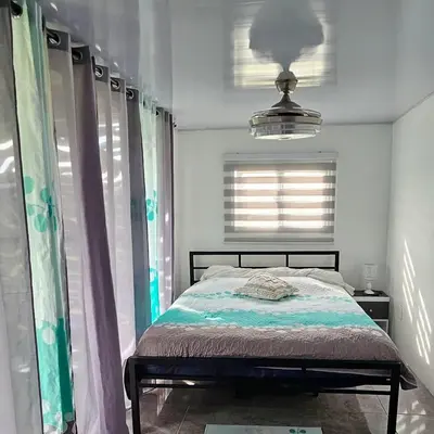a bedroom with a bed and a window at BlueEcolandia bungalows AIRE in Jarabacoa