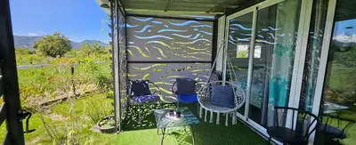 a screened in porch with two chairs and a table at BlueEcolandia bungalows AIRE in Jarabacoa