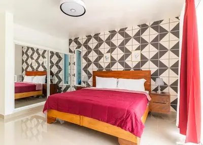 a bedroom with a bed with a red bedspread at Modern Vacation Paradise Villa with Private Pool in Sosúa