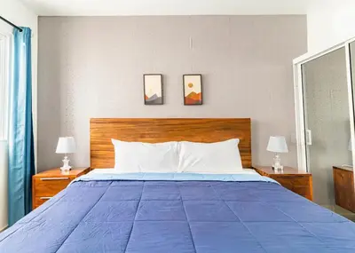 a bedroom with a blue bed with two lamps at Modern Vacation Paradise Villa with Private Pool in Sosúa