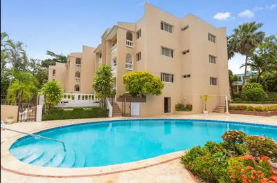 a villa with a swimming pool in front of a building at El Neptuno Residencial, Sosua in Sosúa
