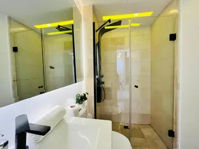 a bathroom with a shower with a toilet and a sink at Paradise Pool Front and Beach Condo at Punta Cana in Punta Cana