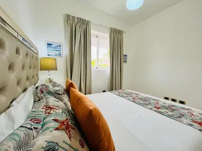 a bedroom with a bed and a window at Paradise Pool Front and Beach Condo at Punta Cana in Punta Cana