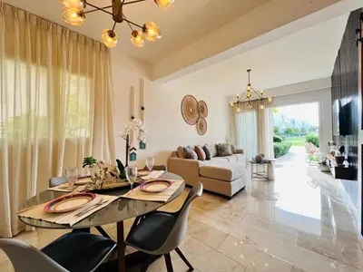 a living room with a dining table and a couch at Paradise Pool Front and Beach Condo at Punta Cana in Punta Cana