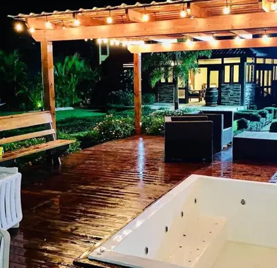 a wooden deck with a pavilion and a bench at Río Privado Villa Jarabacoa con Picuzzi in Jarabacoa