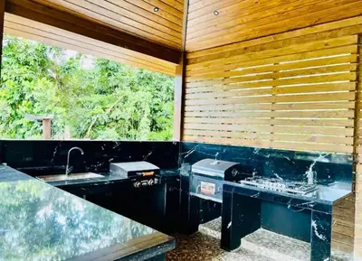 a bathroom with a counter with a sink and a window at Río Privado Villa Jarabacoa con Picuzzi in Jarabacoa