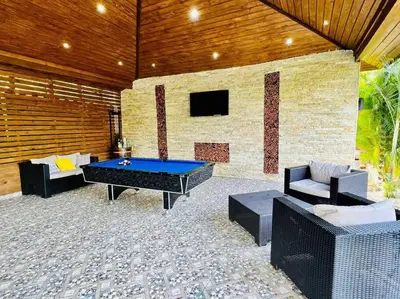a patio with a ping pong table and chairs at Río Privado Villa Jarabacoa con Picuzzi in Jarabacoa