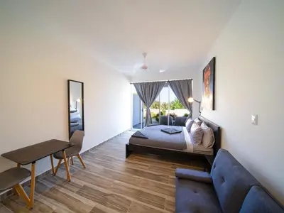 a bedroom with a bed and a couch and a table at Encuentro Studio surf kitesurf Residencia Aris in Cabarete