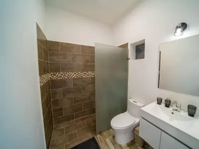 a bathroom with a shower and a toilet and a sink at Encuentro Studio surf kitesurf Residencia Aris in Cabarete