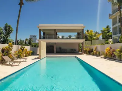 a swimming pool in front of a house at Encuentro Studio surf kitesurf Residencia Aris in Cabarete