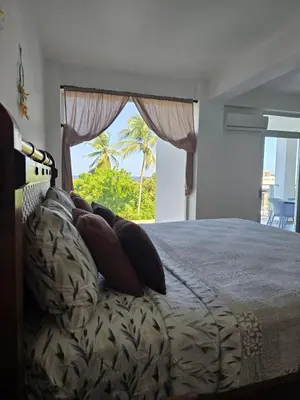 a bedroom with a bed with a view of the ocean at ENCUENTRO 2 BR, Surf, kiting, home Residencial Aris in Cabarete