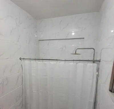 a bathroom with a shower with a white shower curtain at Departamento Sol in Santo Domingo