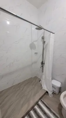 a white bathroom with a shower and a toilet at Departamento Sol in Santo Domingo