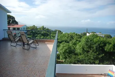 a balcony with chairs and a view of the ocean at E&J Boutique Residences in Sosúa