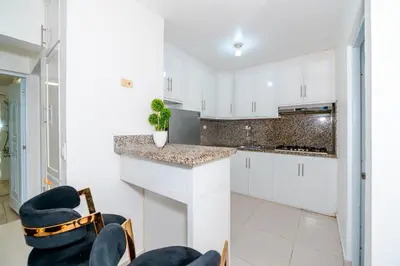 a kitchen with white cabinets and a counter at Villa Campo Sosúa - Apartamento in Sosúa