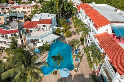 an aerial view of a resort with palm trees and blue umbrellas at Villa Campo Sosúa - Apartamento in Sosúa