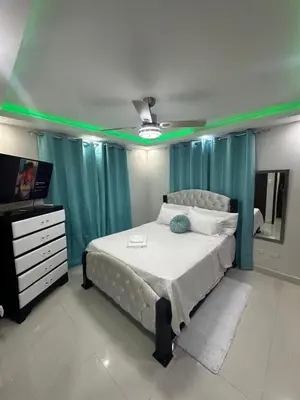 a bedroom with a bed and a television with green lights at Estilo & Confort in Mendoza