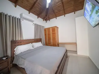 a bedroom with a bed and a television in it at Villa Selena - 5br Villa In Sosua Center in Sosúa