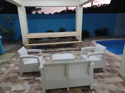 a patio with a table and chairs and a bench at Villa Xiomara in El Jamo