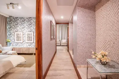 a corridor of a hotel room with a bed and a table at Magical apartment with garden view in Casa de Campo in El Infiernito