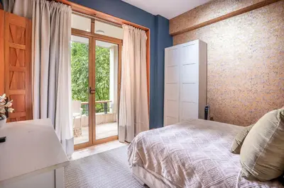 a bedroom with a bed and a large window at Magical apartment with garden view in Casa de Campo in El Infiernito