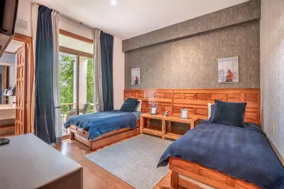 a bedroom with two beds and a table and a window at Magical apartment with garden view in Casa de Campo in El Infiernito